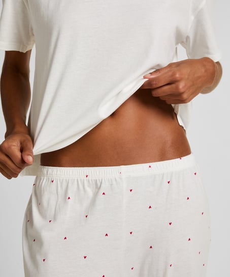 Cozy up in style with this charming pyjama set, designed for ultimate comfort and playful flair. Made from soft, breathable fabric, the set features long pants with an elasticated waist for a perfect, flexible fit and a short-sleeved top. Together, they create a relaxed, coordinated look ideal for lounging or sleeping., White